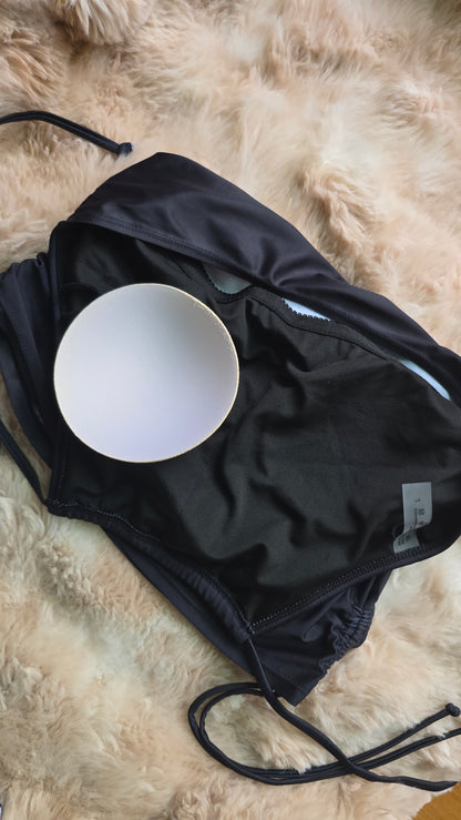 Black swimsuit with a white bowl inside on a fur surface